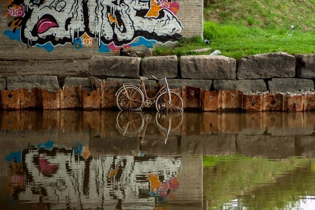 Denne gangen er vi I Lillestrøm og ser deler av Nitelva og under brua mot Strømmen. Der fant jeg en sykkel som sansynligvis ble parkert for godt. Synes det ble et godt bilde med grafittikunsten i bakgrunnen. Bildet er tatt våren 2010.